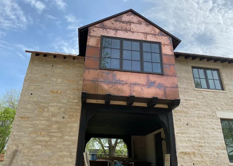 Copper metal panel facade on a stone building for Skylight Installation in Munford